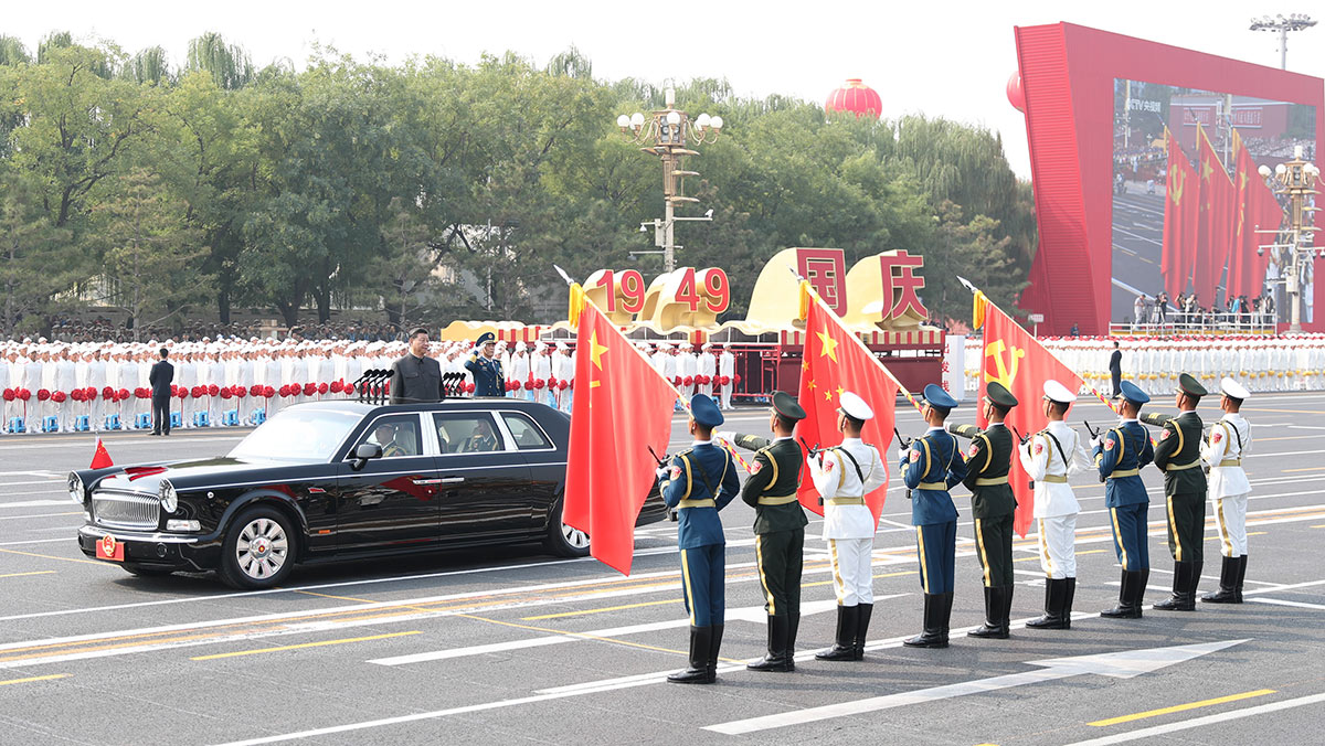 習近平驅(qū)車行進至黨旗、國旗、軍旗前，向旗幟行注目禮